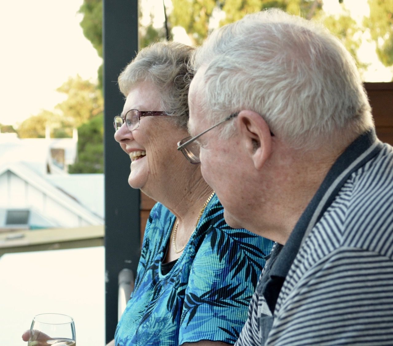 Australian retired couple smiling with a glass of wine